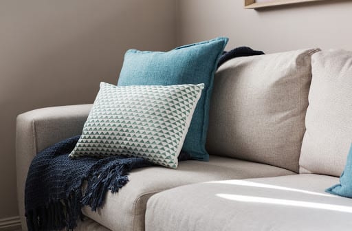 Close up of a fabric sofa with styled cushions