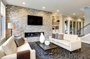 Living room furniture layout with soft color sofas and brick style fireplace.