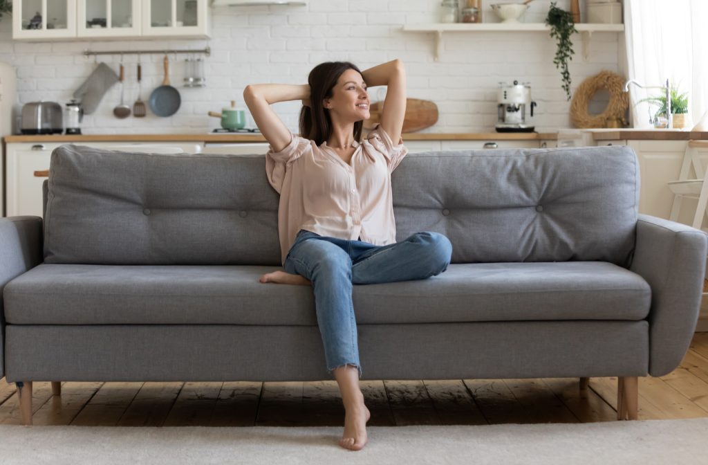 Women sitting on her new sofa purchased in living room of house