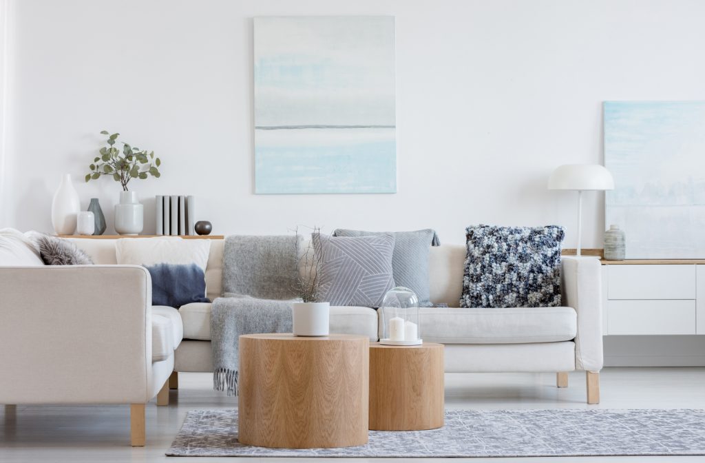 White sectional sofa in living room with wooden tables