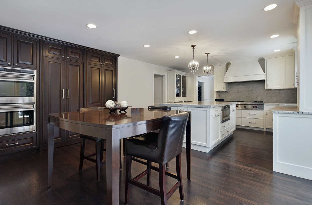 A dark wood dining table set placed in a dining area with similar dark wooden flooring.