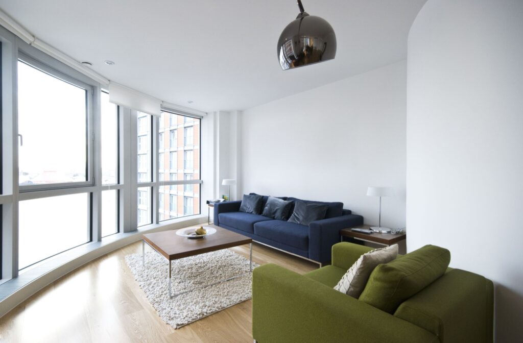 A small, corner-shaped living room with modern furniture pieces placed to fit the room's tight space.