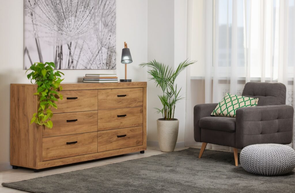 A wooden set of drawers in the corner of a room with modern Canadian furnishings.