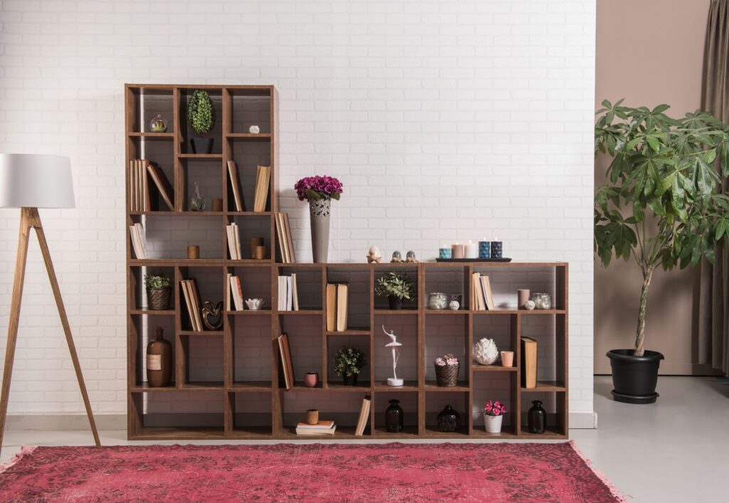 A large wood shelving unit with lots of small cubby spaces to hold things in a smaller living room.